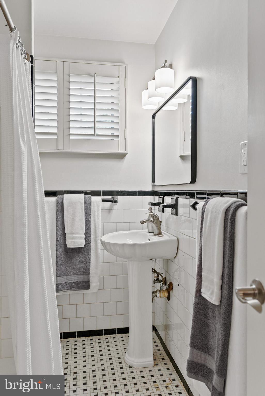 4703 Wyaconda Road Rockville, MD 20852 - Photo 23 of 40 a bathroom with a sink a mirror and a shower