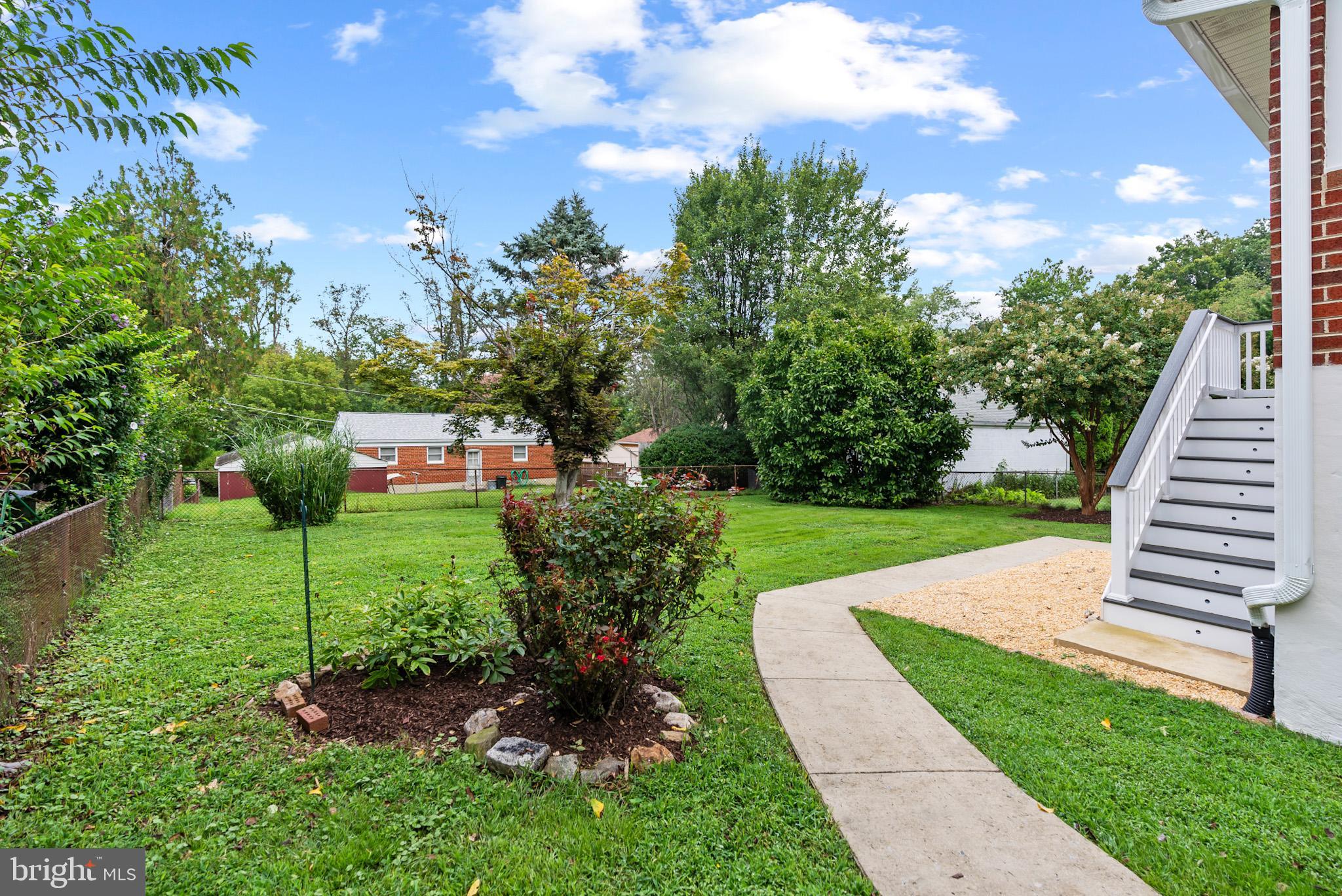 4703 Wyaconda Road Rockville, MD 20852 - Photo 37 of 40 a view of a garden with lawn chairs plants and large tree