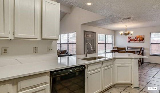 Kitchen island featuring a stainless steel sink with a high-arc faucet, white shaker-style cabinetry, and light-toned countertops