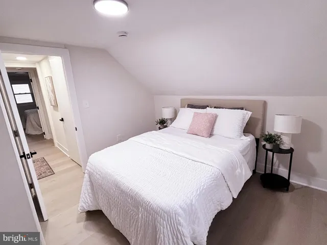 a bedroom with a bed and a flat tv screen on a dresser