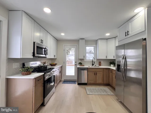 a kitchen with stainless steel appliances granite countertop a stove top oven a sink dishwasher a refrigerator and a refrigerator