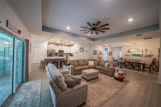 a living room with lots of furniture and a view of kitchen