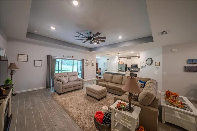 a living room with furniture ceiling fan and a wooden floor