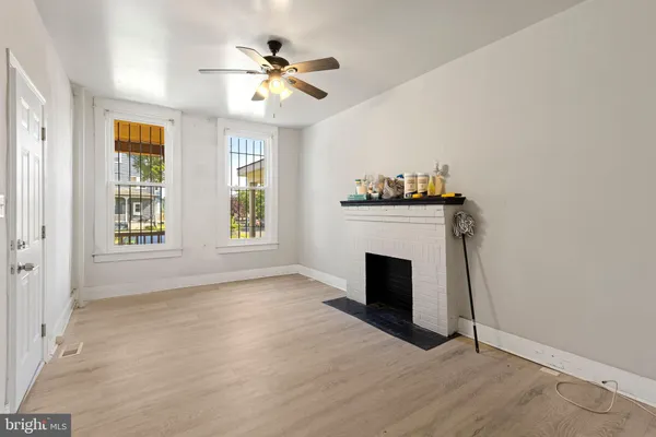 a view of an empty room with a fireplace and a window
