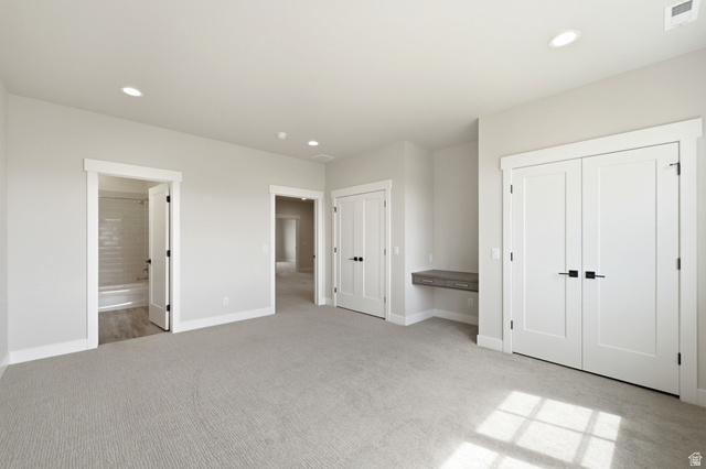 496 North Farmhouse Way, Unit 11 Midway, UT 84049 - Photo 40 of 50 Spacious room featuring light gray carpeting, recessed lighting, white trim, a built-in floating desk, and multiple white panel doors with matte black hardware
