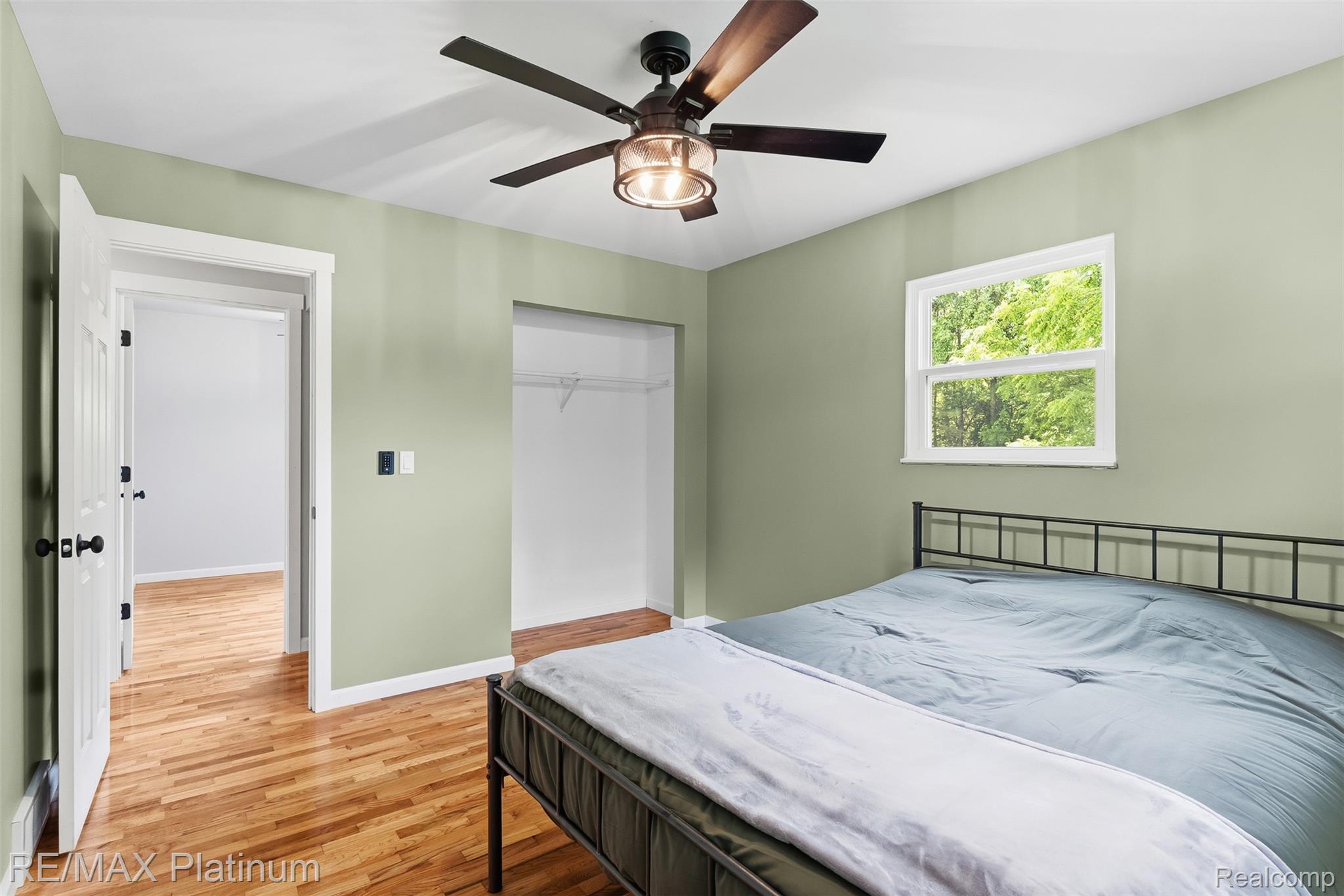 8370 West Rolston Road Linden, MI 48451 - Photo 25 of 36 Bedroom with hardwood flooring, a ceiling fan with integrated lighting, a double-hung window, and an open closet space