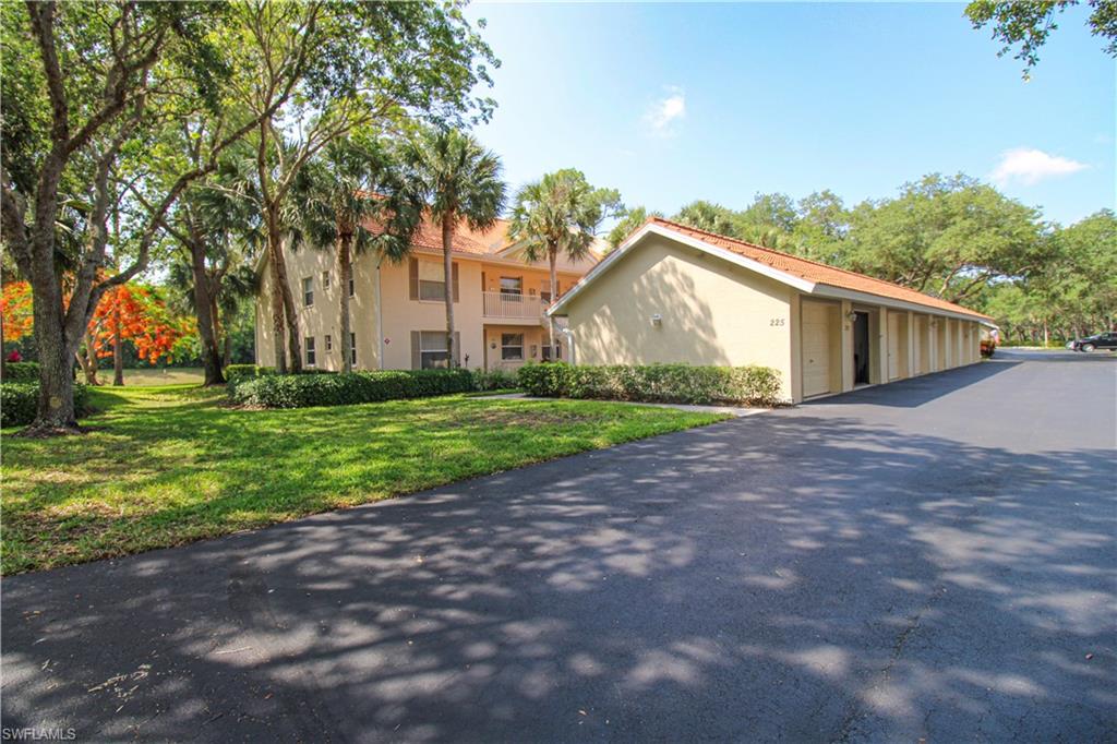 225 Robin Hood Circle, Unit 203 Naples, FL 34104 - Photo 1 of 50 View of front facade featuring a front yard