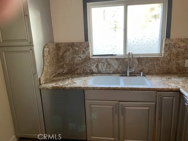 a utility room with granite countertop cabinets washer and dryer