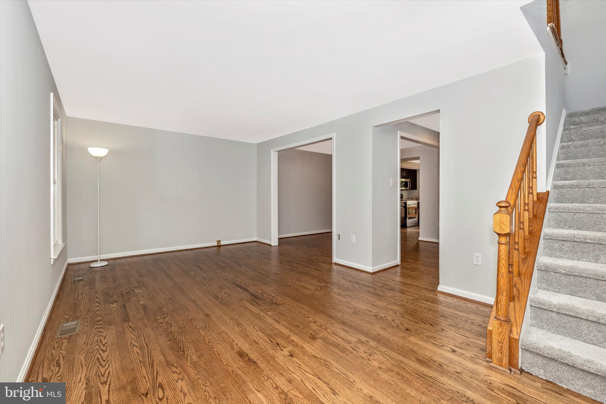 8001 Hollow Reed Court Frederick, MD 21701 - Photo 15 of 33 a view of an empty room with wooden floor and stairs