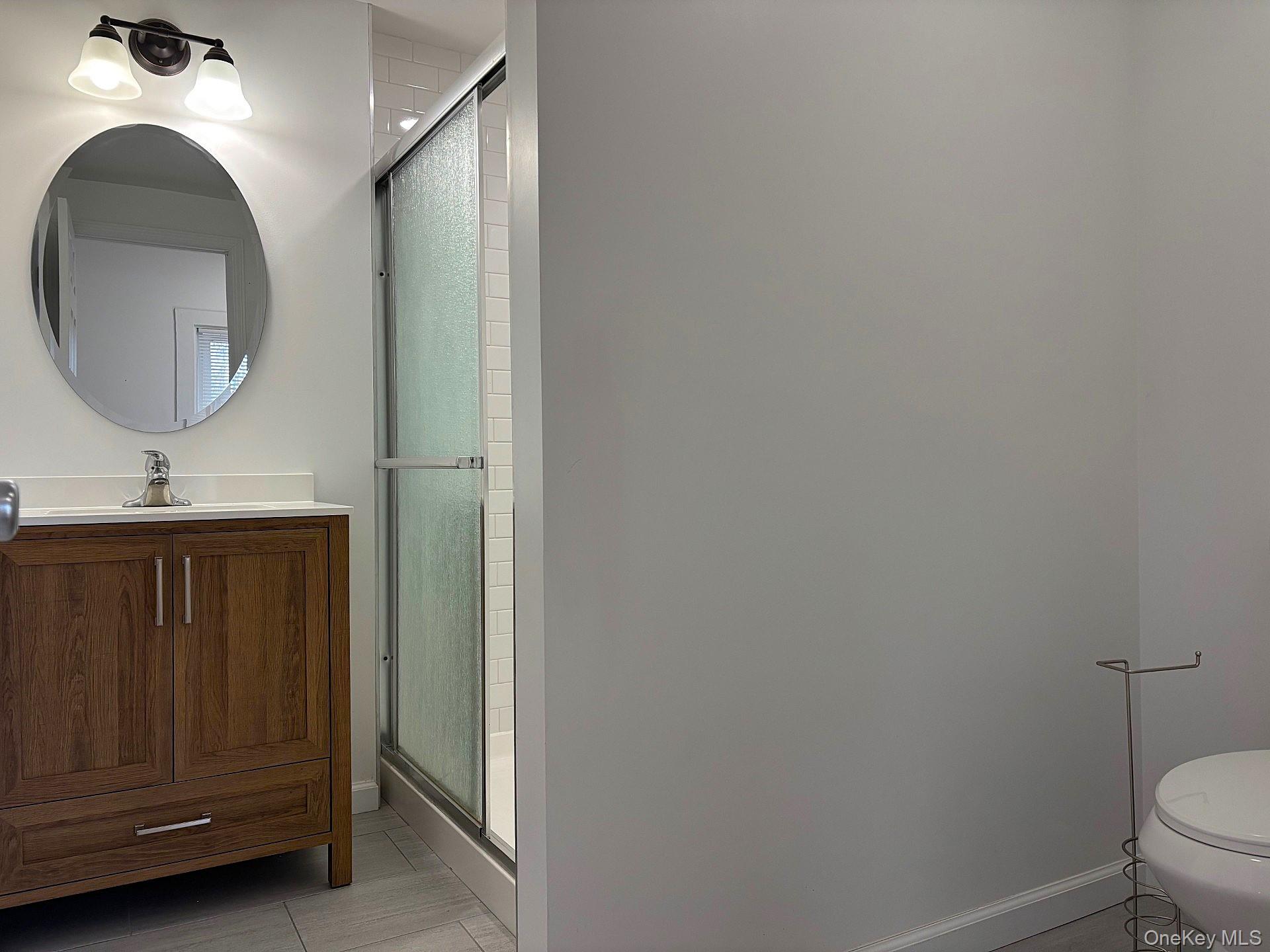 447 Highway 376, Unit 1 Hopewell Junction, NY 12533 - Photo 14 of 18 a bathroom with a toilet a sink and mirror