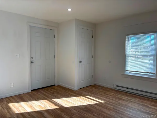 a view of empty room with wooden floor