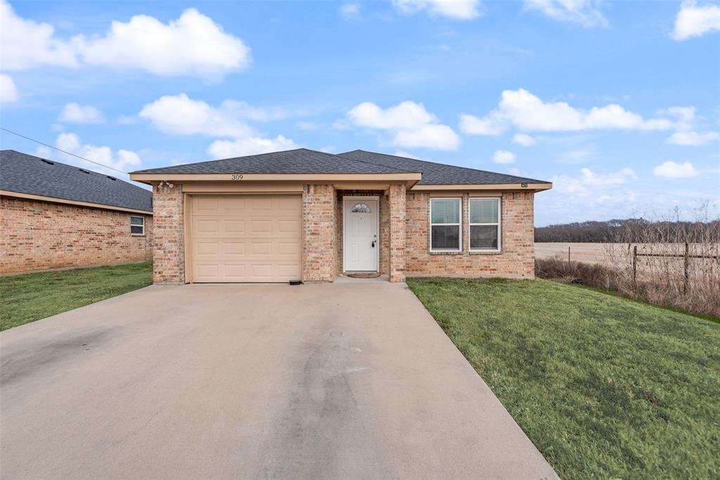 309 East 2nd Street Maypearl, TX 76064 - Photo 1 of 20 a front view of a house with a yard and garage
