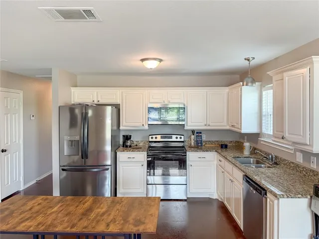 a kitchen with a refrigerator stove and sink
