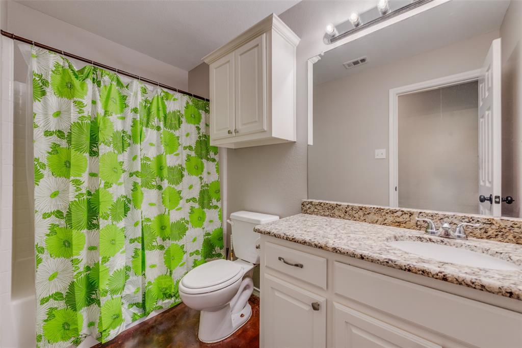 309 East 2nd Street Maypearl, TX 76064 - Photo 9 of 20 a bathroom with a granite countertop toilet sink and mirror