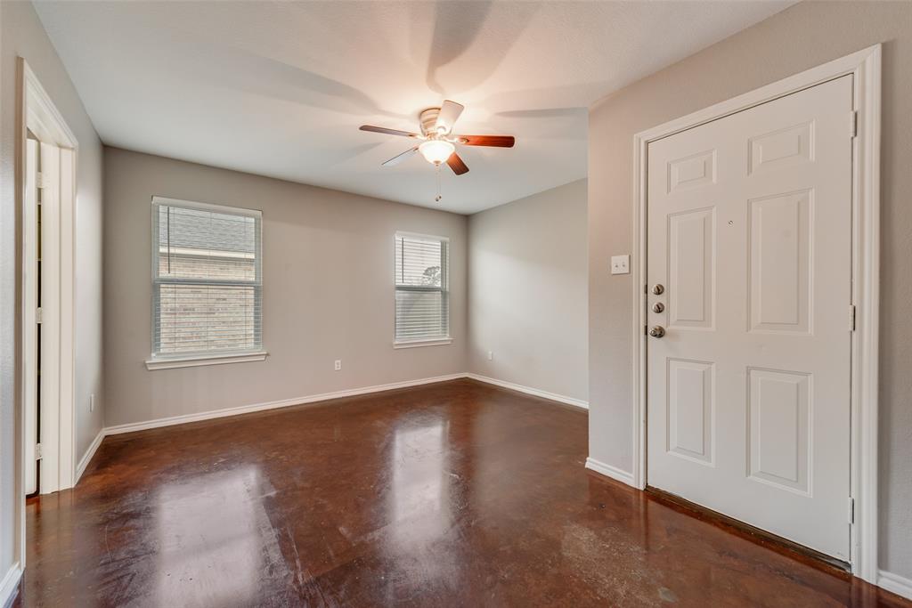 309 East 2nd Street Maypearl, TX 76064 - Photo 10 of 20 an empty room with wooden floor chandelier fan and windows