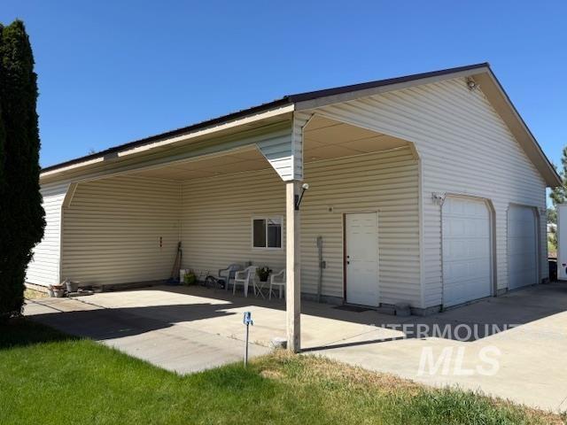 1095 County Road 70 Weiser, ID 83672 - Photo 27 of 44 Detached structure featuring a covered carport, two garage bays, a pedestrian door, and horizontal siding