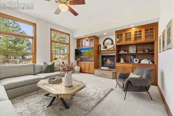 a living room with furniture fireplace and a large window