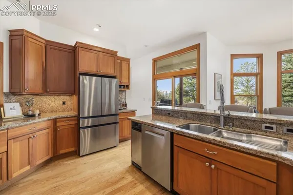 a kitchen with stainless steel appliances granite countertop a sink a stove and cabinets