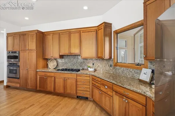 a dining room with furniture large windows and wooden floor