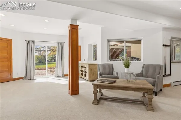 a living room with a floor to ceiling window and a fireplace
