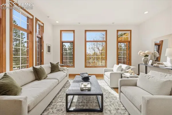 a living room with furniture a fireplace and a large window