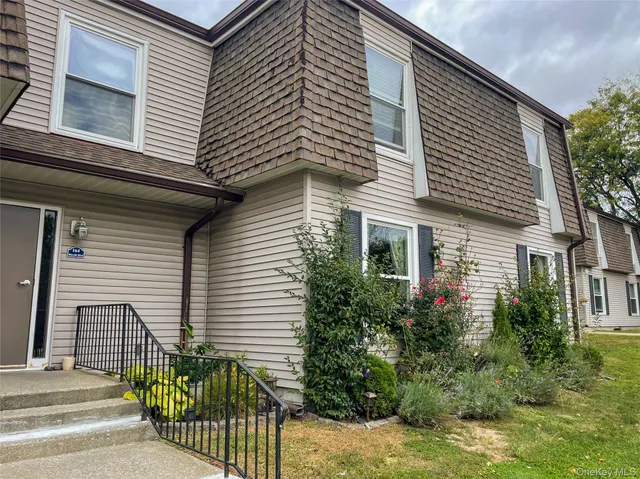 a front view of a house with plants