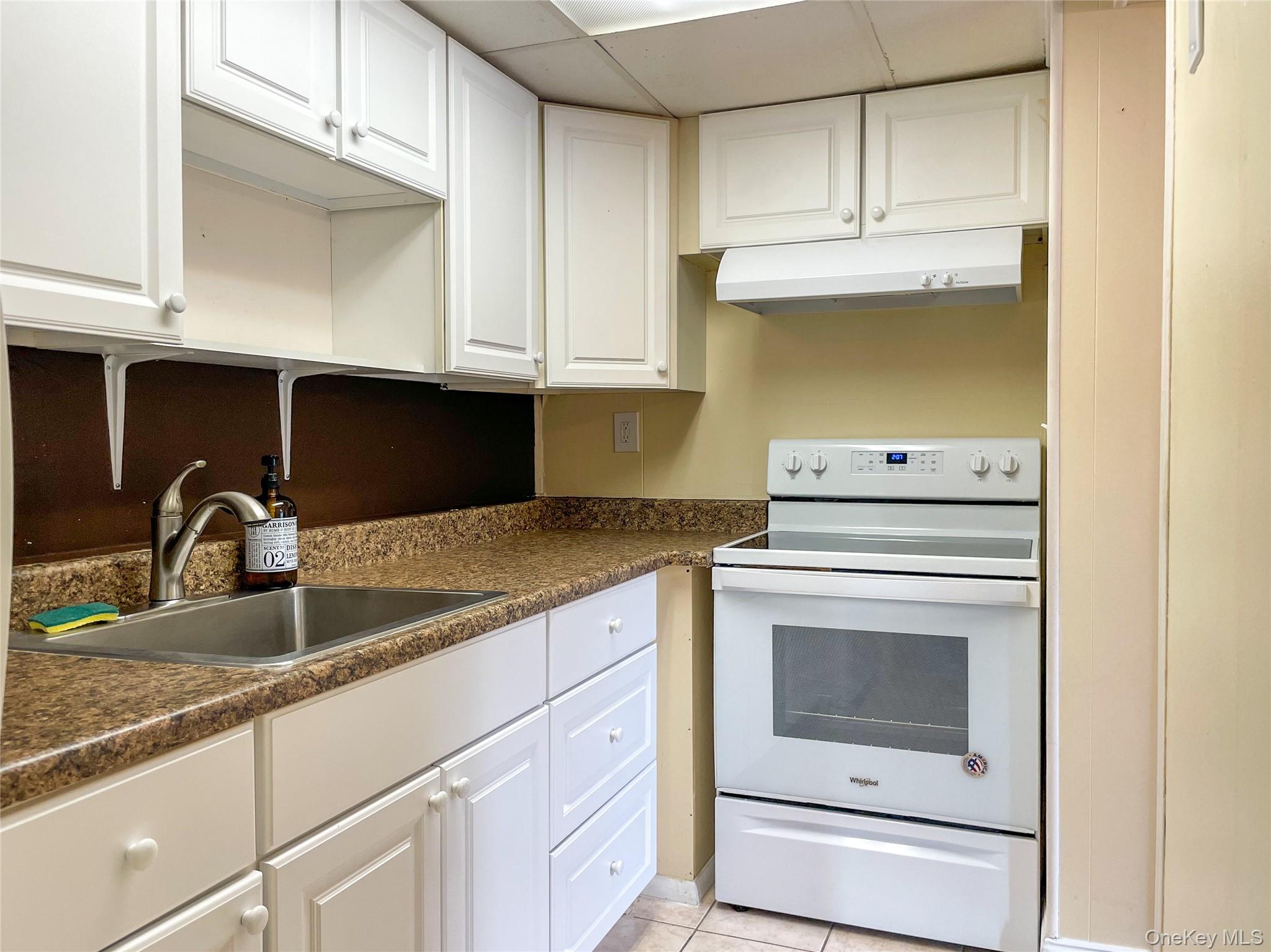 164 Rinaldi Boulevard, Unit B Poughkeepsie, NY 12601 - Photo 6 of 15 a kitchen with granite countertop white cabinets and white appliances