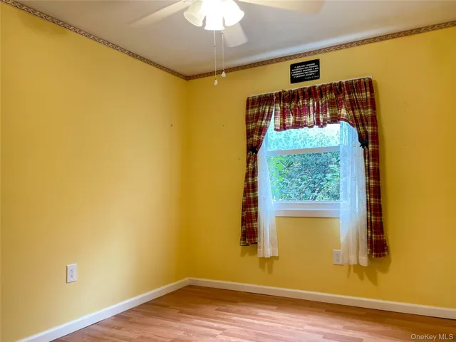 a view of a room with wooden floor and a window