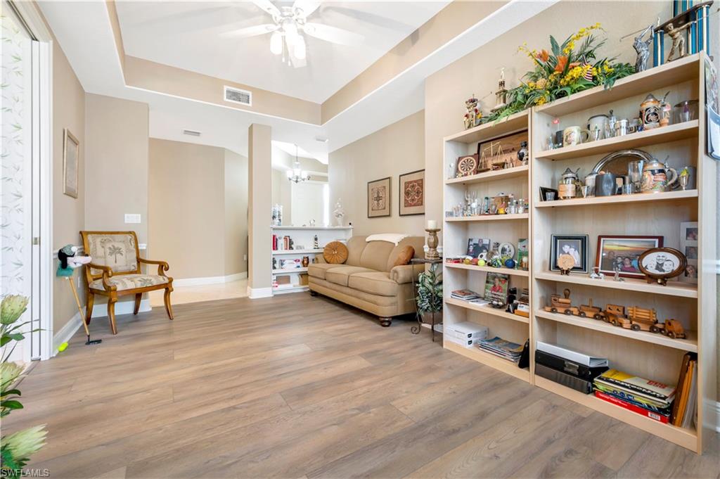 10540 Marino Pointe Drive, Unit 301 Miromar Lakes, FL 33913 - Photo 5 of 43 a living room with furniture and a book shelf