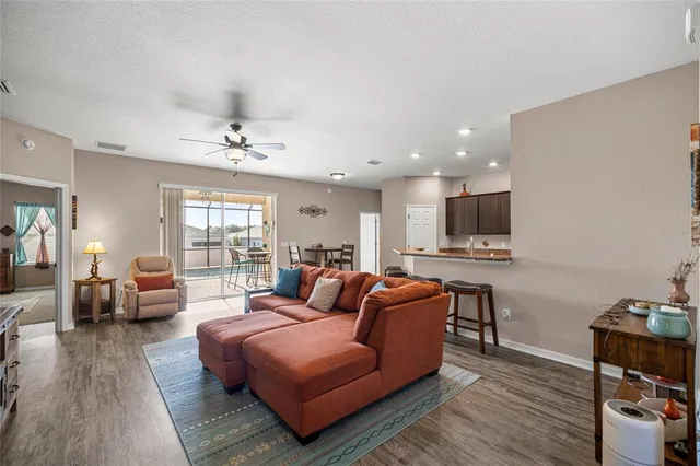 a living room with furniture a flat screen tv and kitchen view
