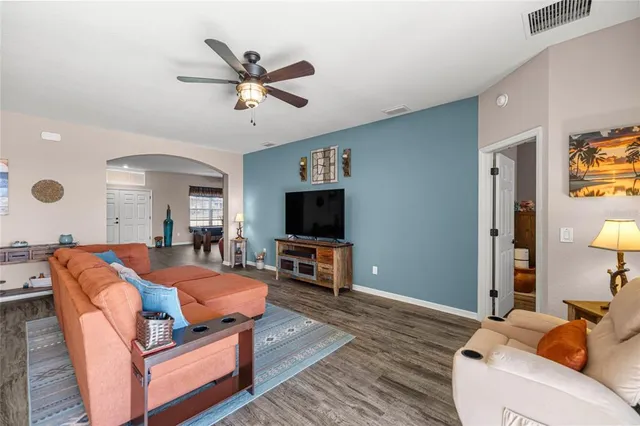 a living room with furniture and a flat screen tv with wooden floor