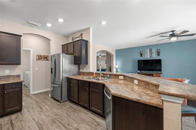 a kitchen with stainless steel appliances granite countertop a refrigerator and a stove top oven