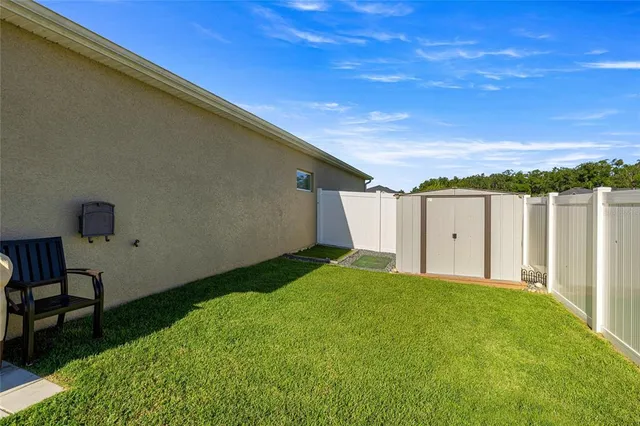 a view of a backyard with table and chairs and a barbeque