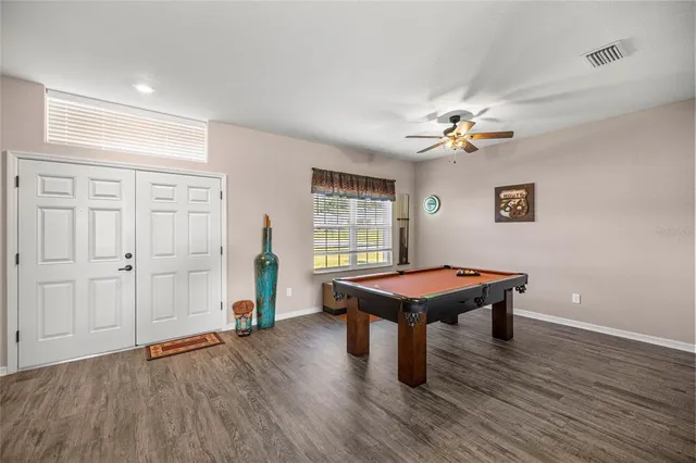 a room with wooden floor and pool table