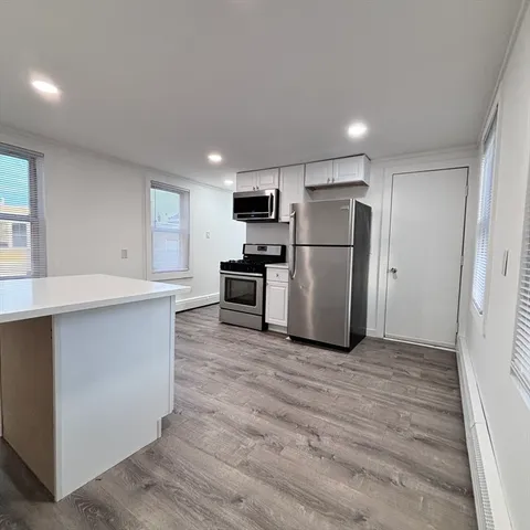 a kitchen with stainless steel appliances a refrigerator and a stove top oven