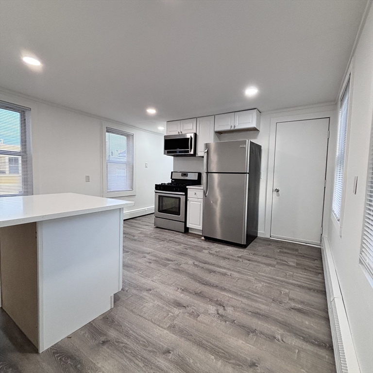 12 Pine Street, Unit 2 Attleboro, MA 02703 - Photo 5 of 20 a kitchen with stainless steel appliances a refrigerator and a stove top oven