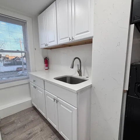 a kitchen with stainless steel appliances granite countertop a sink and dishwasher with white cabinets