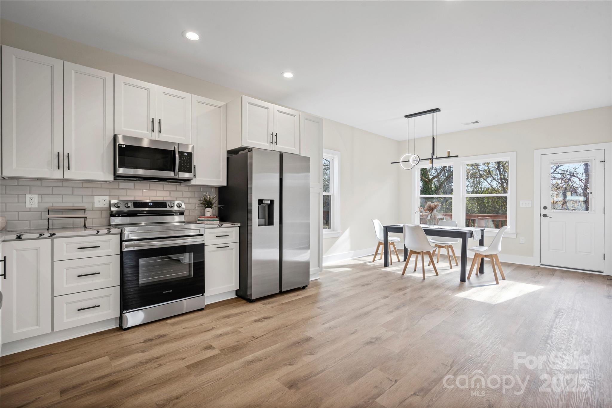 241 Booker Drive Southwest Concord, NC 28025 - Photo 9 of 29 a kitchen with granite countertop a refrigerator stove and microwave