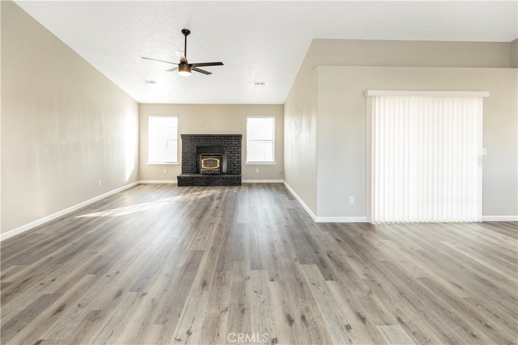 28702 Rancho Avenue Madera, CA 93638 - Photo 15 of 34 a view of an empty room with wooden floor fireplace and a window