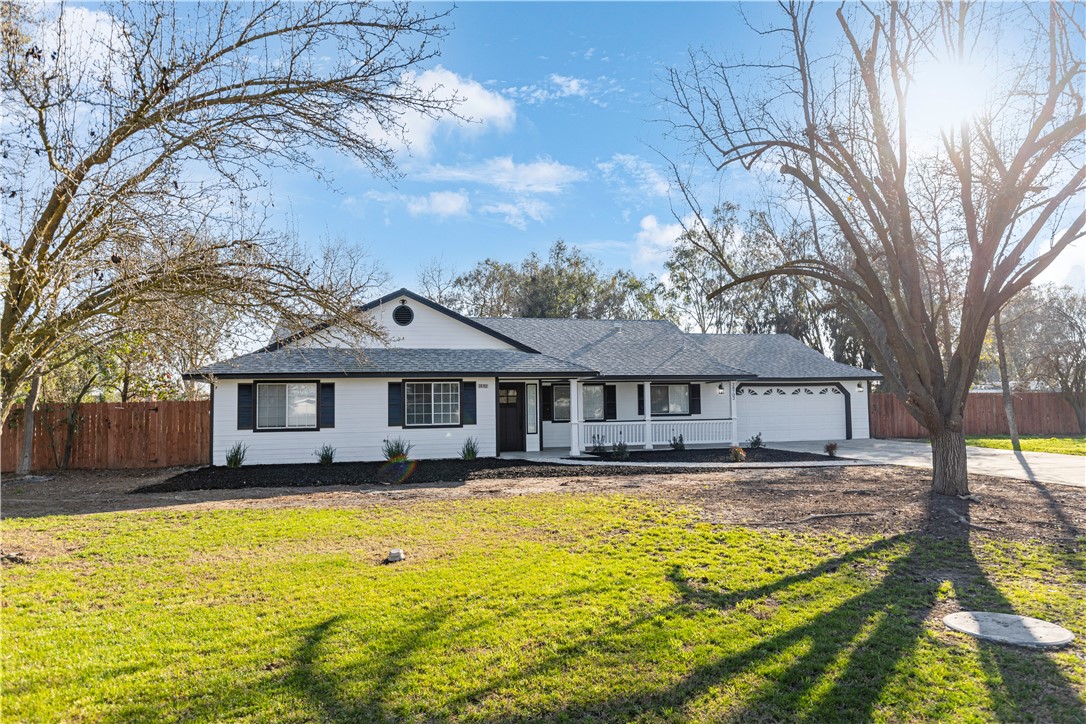 28702 Rancho Avenue Madera, CA 93638 - Photo 3 of 34 a front view of a house with a yard table and chairs