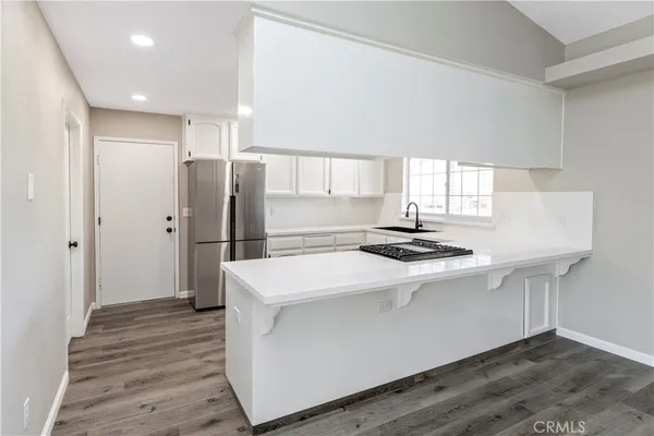 a kitchen with white cabinets and white appliances