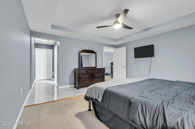 a spacious bedroom with a bed and a television