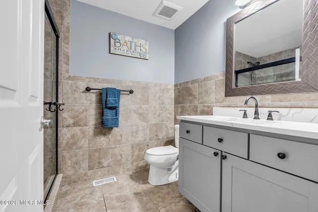 a bathroom with a sink mirror and a toilet