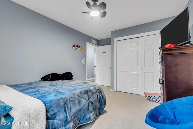 a bedroom with a bed and a flat tv screen on a dresser