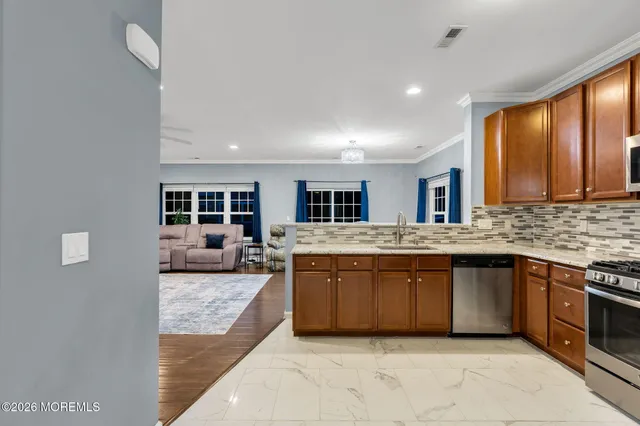 a large kitchen with stainless steel appliances granite countertop a sink and cabinets