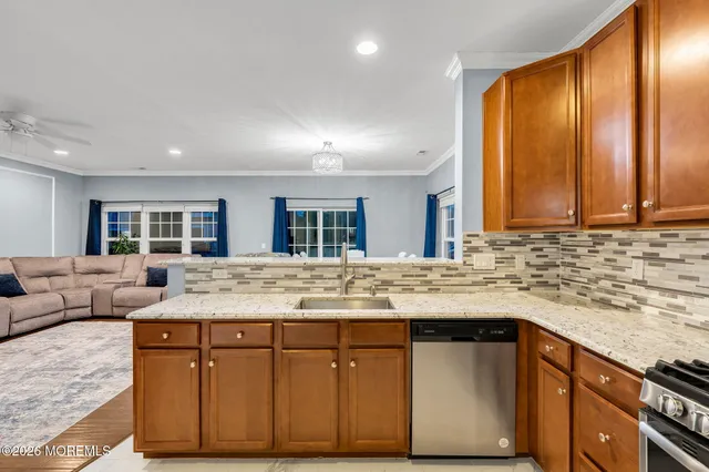 a kitchen with kitchen island granite countertop a sink and cabinets