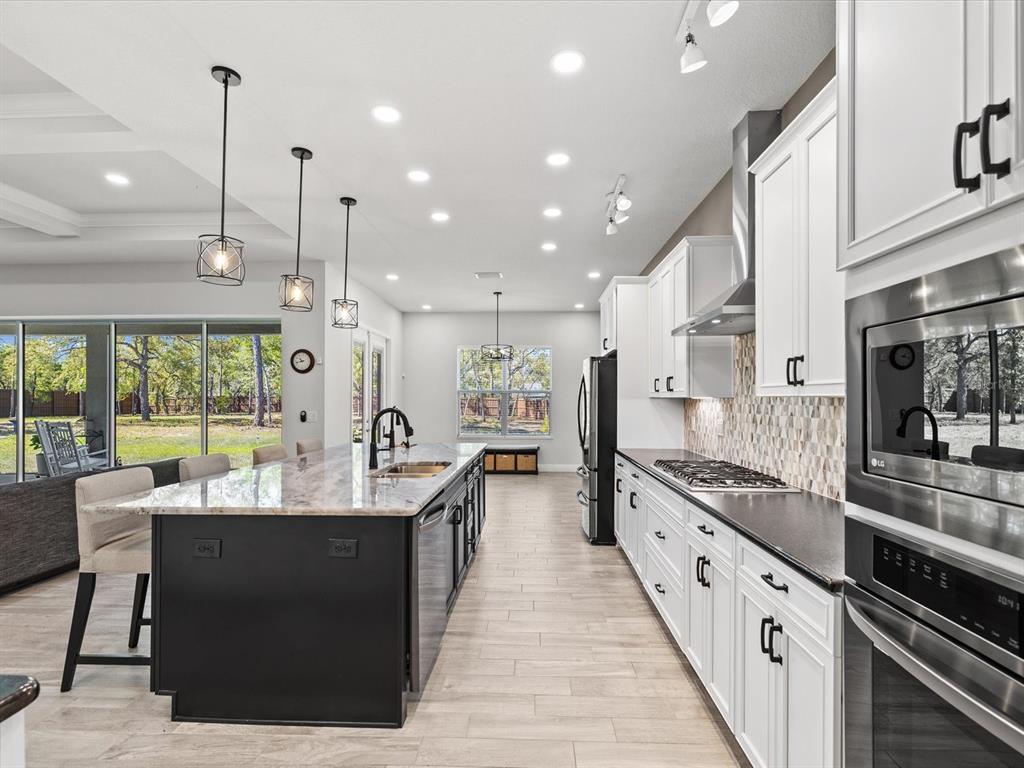 11981 Robina Road Weeki Wachee, FL 34614 - Photo 12 of 93 a large kitchen with stainless steel appliances kitchen island a large island in the center