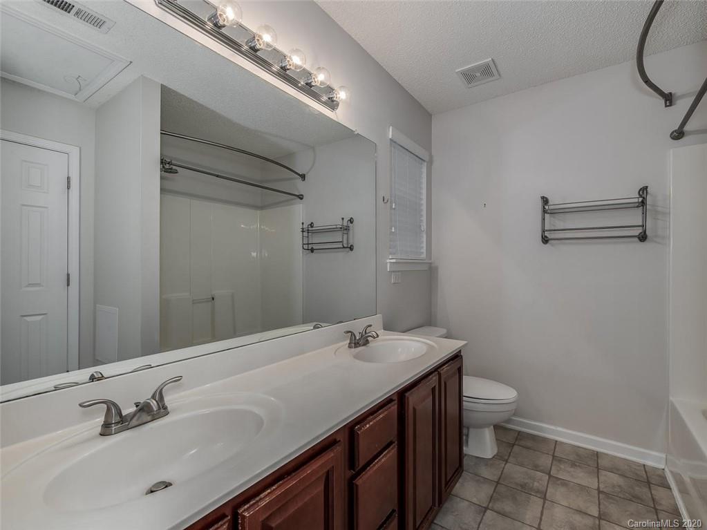 8376 Rudolph Road Charlotte, NC 28216 - Photo 13 of 17 a bathroom with a sink a toilet and a mirror
