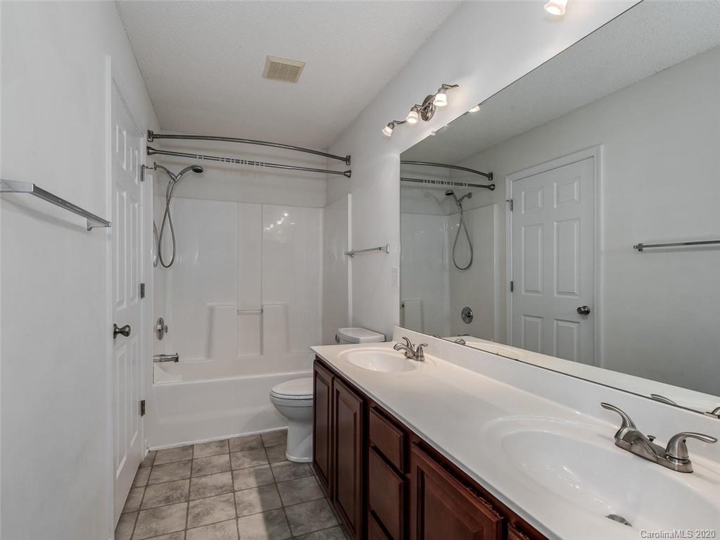 8376 Rudolph Road Charlotte, NC 28216 - Photo 7 of 17 a bathroom with a sink double vanity granite tub shower and a mirror