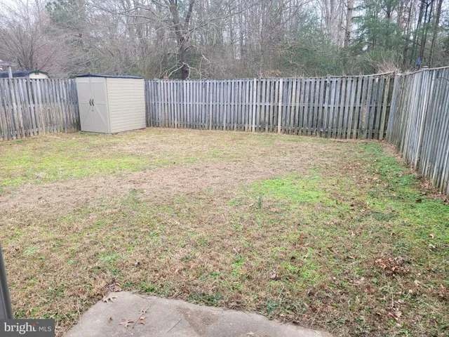a view of a backyard with wooden fence